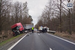 na zdjęciu odcinek droga, na którym stoją rozbite pojazdy, osoby i policjant