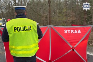 na zdjęciu policjant przy czerwonym parawanie z napisem straż