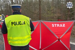 na zdjęciu policjant przy czerwonym parawanie z napisem straż