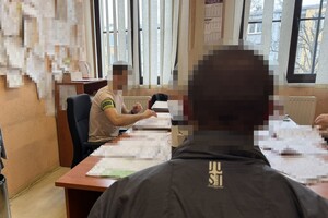 na zdjęciu zatrzymany mężczyzna przy biurku, za którym siedzi kryminalny