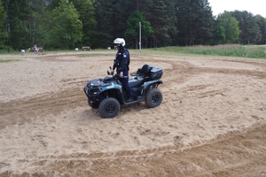 na zdjęciu policjant na quadzie na plaży