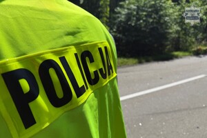 na zdjęciu fragment policyjnej kamizelki i jezdnia
