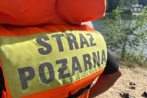 na zdjęciu fragment kamizelki strażackiej przy plaży