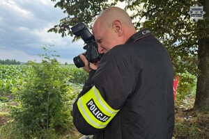na zdjęciu policjant z aparatem