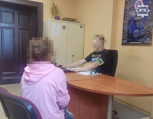 na zdjęciu kobieta przy biurku, za którym siedzi policjant