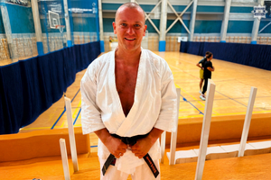 na zdjęciu aspirant Kazienko w białym stroju karate i czarnym pasie