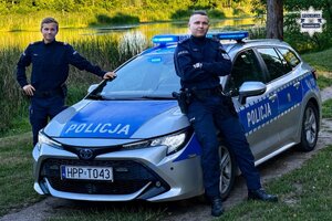 na zdjęciu policjanci przy radiowozie nad akwenem