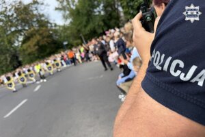 na zdjęciu fragment munduru policjanta i czoło pochodu