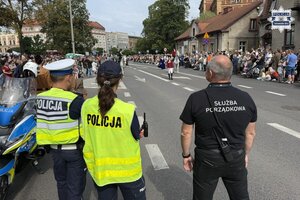 na zdjęciu policjant, policjantka i pracownik służby porządkowej na jezdni