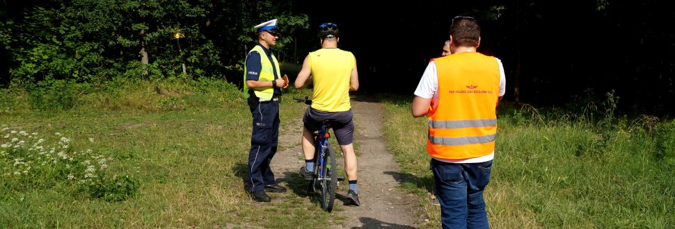 Policjant oraz pracownicy PLK i SOK rozmawiają z rowerzystą.