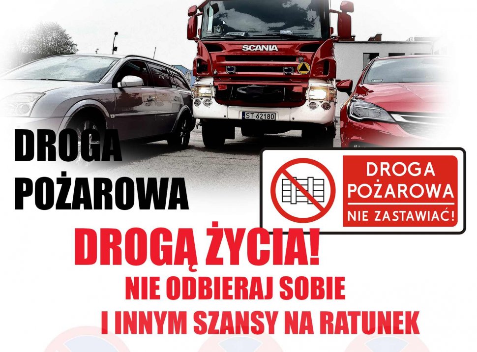 Na zdjęciu widoczny wóz strażacki pomiędzy dwoma samochodami oraz napis "Droga pożarowa drogą życia!Nie odbieraj sobie i innym szansy na ratunek" , "Droga pożarowa-nie zastawiać." 