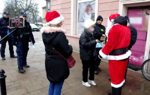 Mikołaj rozmawia z osobami, widoczni strażnicy miejscy i policjanci.