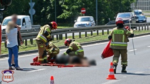 Strażacy podczas udzielania pierwszej pomocy poszkodowanemu w zdarzeniu drogowym.