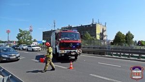 Wóz Straży Pożarnej oraz strażak zabezpieczający miejsce zdarzenia drogowego.
