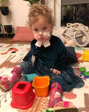 Mała dziewczynka siedzi i bawi się foremkami.