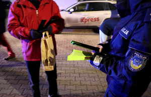 Na zdjęciu umundurowany policjant wręczający odblaski.