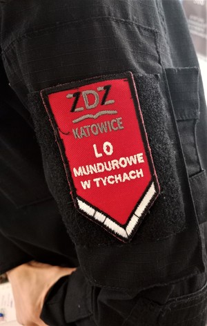 Na zdjęciu naszywka na mundurze szkolnym z napisem o treści:  ZDZ Katowice LO Mundurowe w Tychach