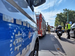 Na zdjęciu radiowóz, wóz straży pożarnej oraz policyjny motocykl. Obok nich funkcjonariusze.