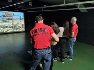 Na zdjęciu instruktor oraz młode osoby na strzelnicy.