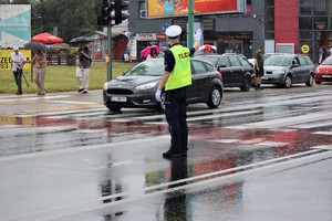 Na zdjęciu policjant kierujący ruchem na skrzyżowaniu.