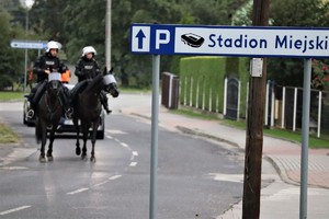 Na zdjęciu patrol policji konnej obok znaku, na którym widnieje napis Stadion Miejski