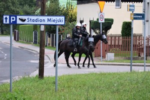 Na zdjęciu patrol policji konnej obok znaku, na którym widnieje napis Stadion Miejski