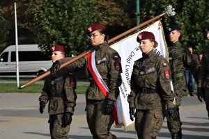 Na zdjęciu uczniowie szkoły mundurowej niosący sztandar.