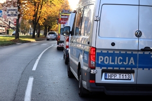 Na zdjęciu oznakowany radiowóz Policji i Straży Pożarnej, stojące na jezdni.