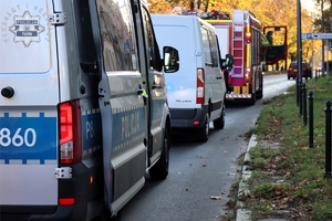 Na zdjęciu oznakowany radiowóz Policji, samochód dostawczy oraz wóz straży pożarnej.