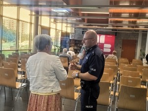 Na  policjant rozmawiający z kobietą