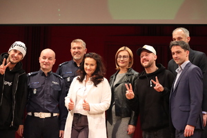 kolorowe zdjęcie gości honorowych wraz z artystami stojącymi na scenie