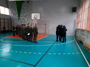 Kolorowe zdjęcie uczniów klas mundurowych podczas zbiórki na sali gimnastycznej.