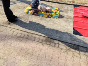 Kolorowe zdjęcie dziecka pochylającego się nad fantomem do treningu resuscytacji krążeniowo-oddechowej.