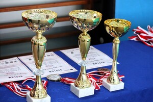 Stół na którym stoją puchary oraz leżą medale.