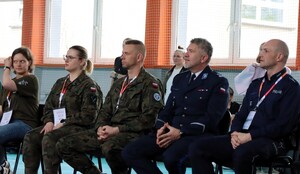 Goście honorowi siedzący na krzesłach w tym Komendant Komendy Miejskiej Policji w Tychach mł. insp. Tomasz Zawadzki.
