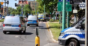 Oznakowane radiowozy Policji przemieszczające się ulicami miasta.