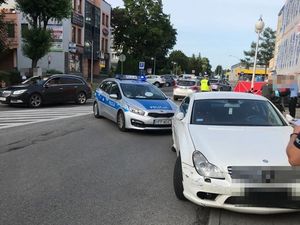 na zdjęciu widać policyjne radiowozy i policjanta podczas czynności na miejscu wypadku drogowego