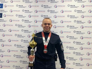 policjant trzyma w ręku puchar, na szyi ma medal mistrzostw Europy