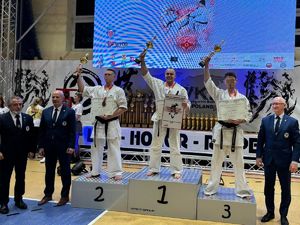 na pierwszym miejscu podium stoi wodzisławski policjant w stroju do karate