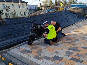 policjant pomaga usunąć usterkę w motocyklu