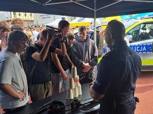 policjant podczas rozmowy z uczestnikami Targów edukacyjnych