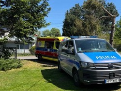 na terenie posesji stoją radiowóz i karetka pogotowia