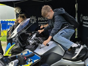chłopiec siedzi na policyjnym motocyklu