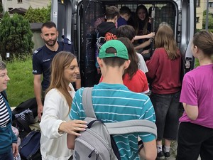 uczestnicy festynu profilaktycznego stoją przy policyjnym stanowiku
