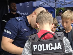 uczestnicy festynu profilaktycznego stoją przy policyjnym stanowisku