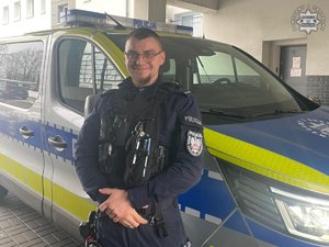 policjant dzielnicowy stoi obok radiowozu