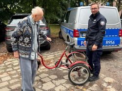 policjant stoi obok seniora oraz jego roweru