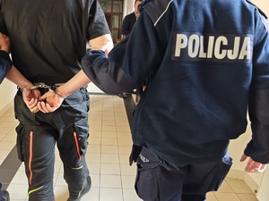 na zdjęciu widać zatrzymanego mężczyznę, który jest prowadzony przez policjantów