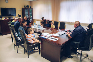 Małego chłopiec i jego rodzina z policjantami w gabinecie komendanta.