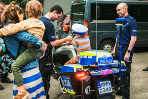 Policjanci pokazują motocykl małemu chłopcu